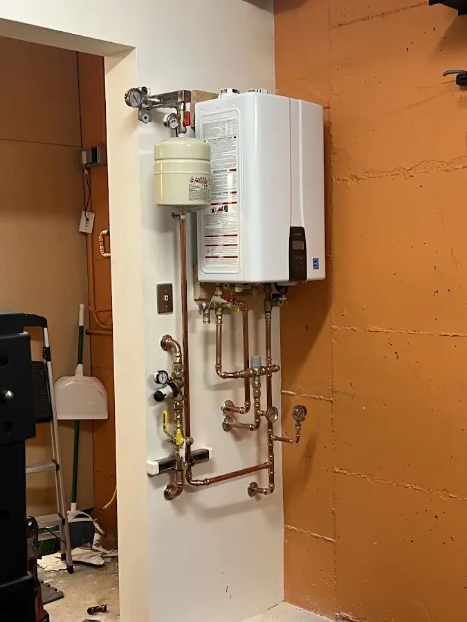 Plumbing technician inspecting water heater connections in Ranson corporation